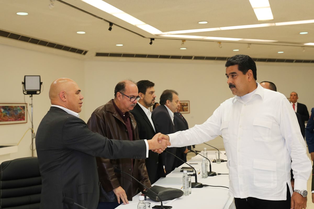 El presidente de Venezuela, Nicolas Maduro (d), saluda al secretario de la coalición opositora Mesa de la Unidad Democrática (MUD), Jesús Torrealba, durante la reunión entre oposición y Gobierno. (Foto Prensa Libre. EFE).