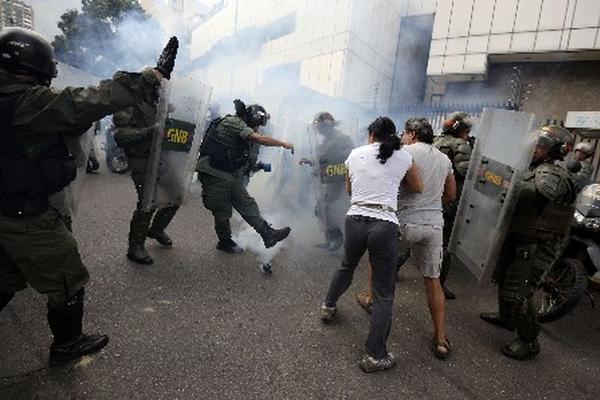 Integrantes de la Guardia Nacional se enfrentan contra manifestantes en Caracas. (Foto Prensa Libre:AFP)