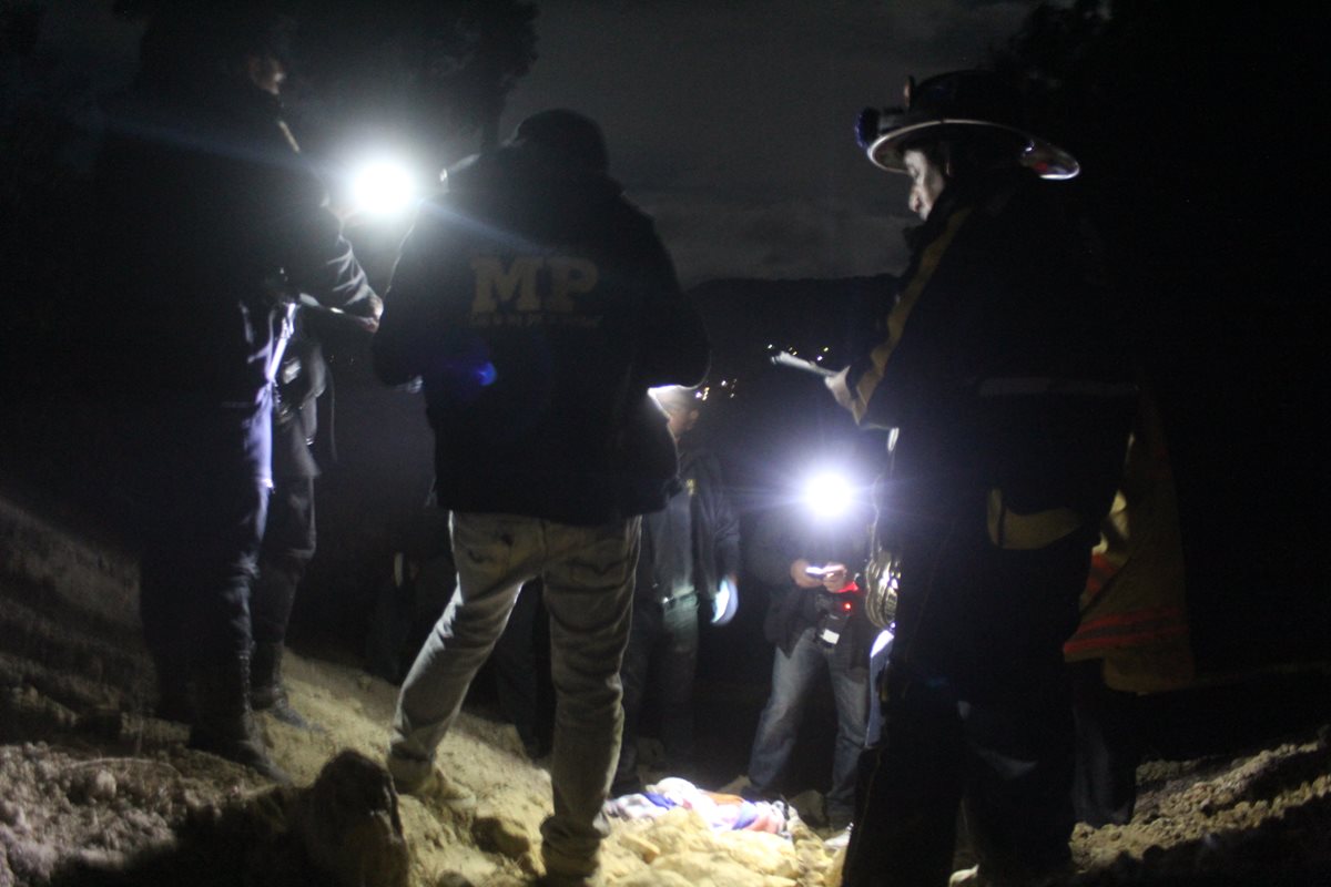 Policías y fiscales del MP, en el momento que identifican a la recién nacida. (Foto Prensa Libre: Ángel Julajuj)