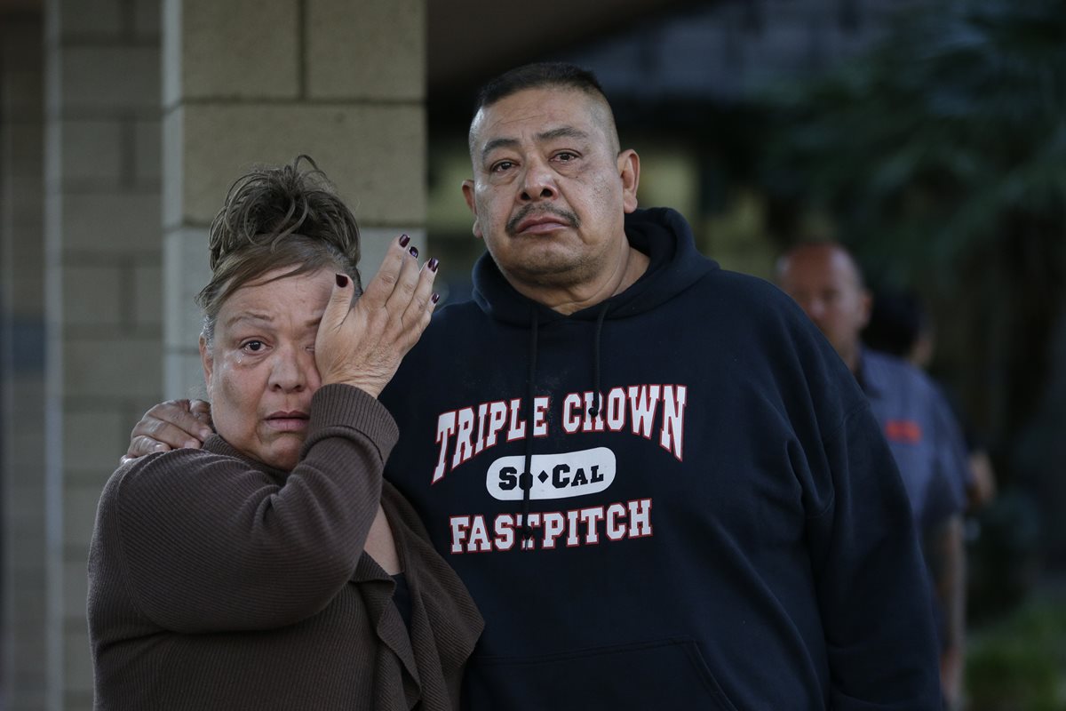 Dos hispanos llegan al lugar de la matanza en busca de sus familiares. (Foto Prensa Libre: AP).