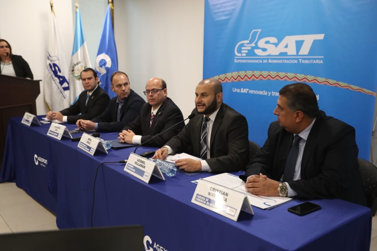 El jefe de la SAT, Abel Cruz y el intendente de fiscalización, Leonel Villamar, brindaron los datos acerca de los daños del incendio. Les acompañan directivos de las Cámaras de Industria y de Comercio así como Agexport. (Foto, Prensa Libre: Óscar Rivas).