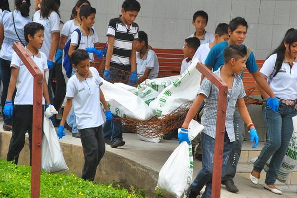 Estudiantes cargan costales con basura que recogieron en calles de Retalhuleu. (Foto Prensa Libre: Jorge Tizol)<br _mce_bogus="1"/>