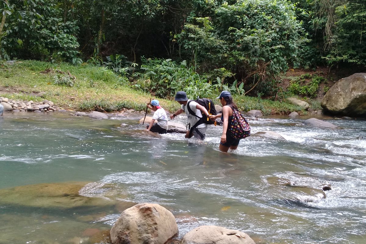 Tres excursionistas atraviesan el río La Puerta que pasa por Malacatán. (Foto Prensa Libre: Whitmer Barrera)