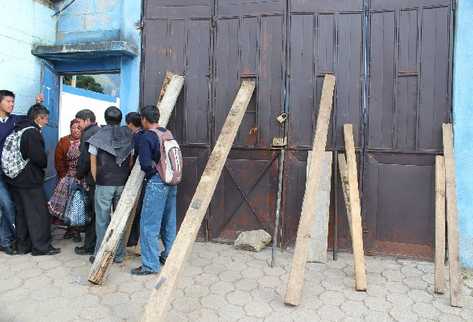 estudiantes, con el apoyo de algunos padres, mantienen cerrada con palos la puerta del Instituto  Normal Rural, en Totonicapán,  que ayer ocuparon en protesta contra el Mineduc.