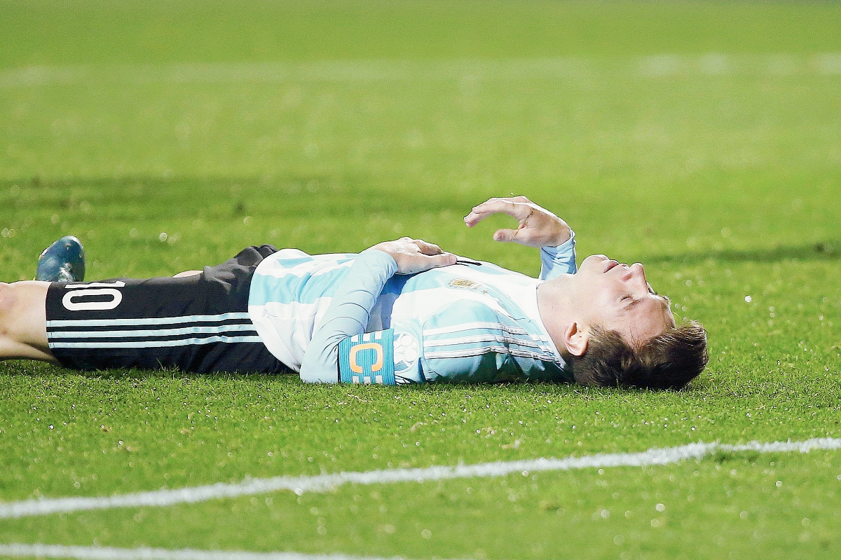 El delantero argentino Lionel Messi tendido sobre el césped durante el partido Argentina-Colombia. (Foto Prensa Libre: EFE)