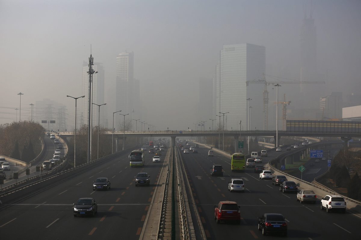  Vehículos circulan por la contaminada ciudad de Pekín, China. (Foto Prensa Libre: EFE).