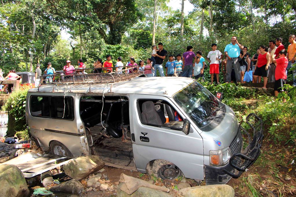 Curiosos obervan el microbus que cayó en una hondonada en el cantón El Zapote, San Martín Zapotitlán, Retalhuleu. (Foto Prensa Libre: Rolando Miranda)