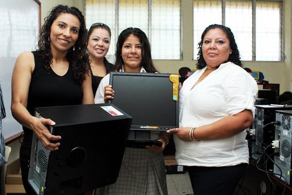 Autoridades educativas y una estudiante muestran una de las computadoras donadas a la Escuela Normal Intercultural de Nuevo San Carlos. (Foto Prensa Libre: Rolando Miranda)