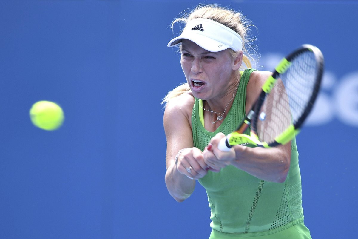 La tenista danesa Caroline Wozniacki devuelve la bola a la puertorriqueña Mónica Puig. (Foto Prensa Libre: EFE)