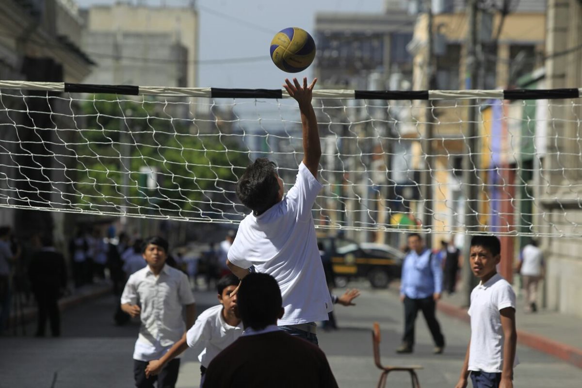 Estudiantes del Central para Varones juegan voleibol en la vía pública, como protesta contra la estigmatización de la juventud. (Foto Prensa Libre: Edwin Bercián)