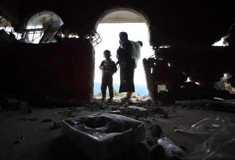 Una mujer y su hijo observan los daños  que sufrió la casa de su familia y que quedó inhabitable, en Sibinal, San Marcos.