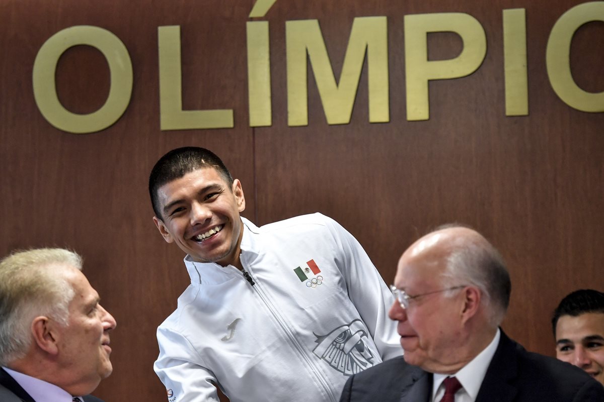 El boxeador Joselito Velázquez saluda al presidente mexicano del Comité Olímpico de México Pablo Padilla Becerra y al ministro de Salud José Narro. (Foto Prensa Libre: AFP)