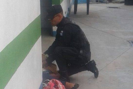 Momento en el que agente auxilia a Nancy Felipe Aguilón, en Mixco. (Foto Prensa Libre: PNC).