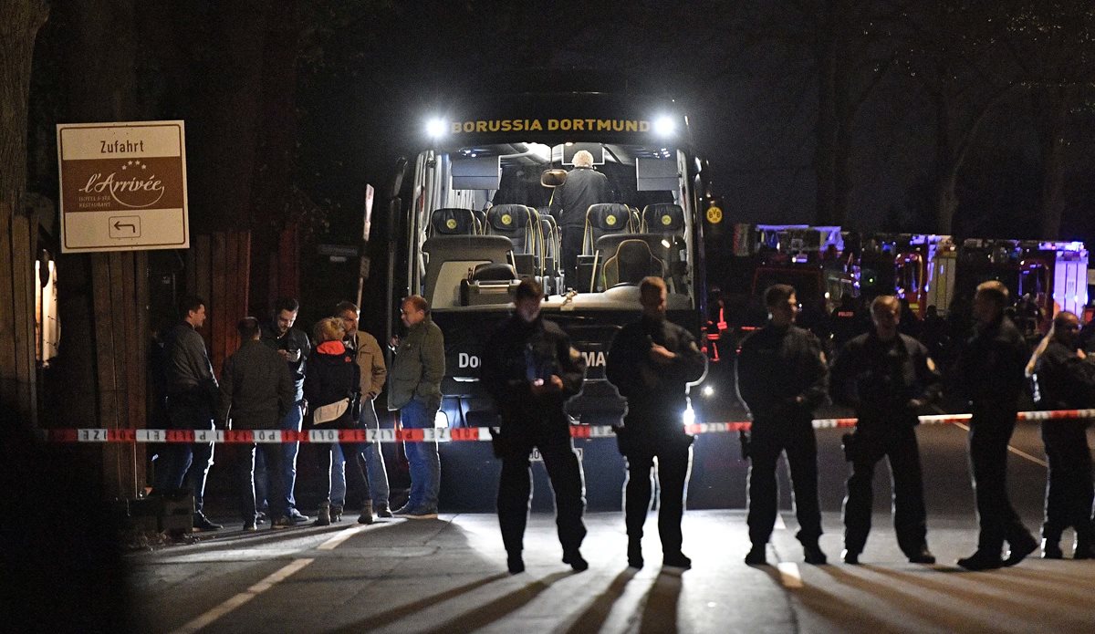 Police officers stand in front of Dortmund's damaged team bus after an explosion before the Champions League quarterfinal soccer match between Borussia Dortmund and AS Monaco in Dortmund, western Germany, Tuesday, April 11, 2017. (AP Photo/Martin Meissner)