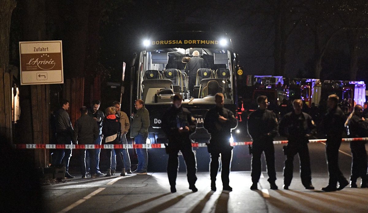 Police officers stand in front of Dortmund's damaged team bus after an explosion before the Champions League quarterfinal soccer match between Borussia Dortmund and AS Monaco in Dortmund, western Germany, Tuesday, April 11, 2017.  (AP Photo/Martin Meissner)