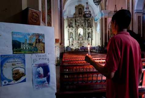 Carteles de bienvenida al Papa Benedicto XVI, que visitará Cuba entre el 26 al 28 de marzo, se pueden ver a la entrada de una iglesia de La Habana. (Foto Prensa Libre: AFP)
