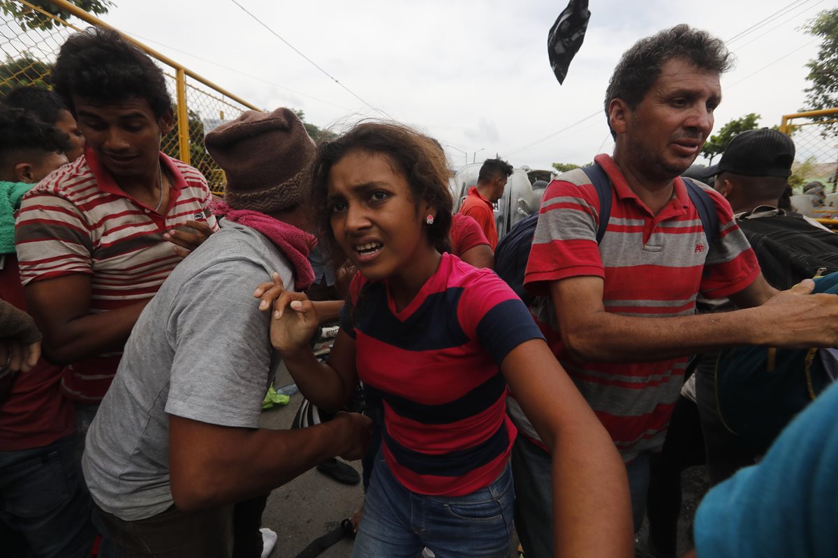 Una mujer trata de ponerse a salvo durante una protesta violenta en la frontera de Tecún Umán, San Marcos, protagonizada por migrantes hondureños. (Foto Prensa Libre: EFE)