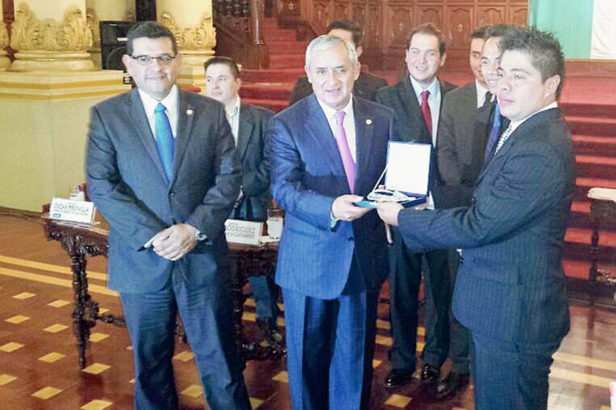 El Presidente Otto Pérez entregó la medalla a Luis rodríguez, representante de Guateambiente. (Foto Prensa Libre: Jessica Gramajo)