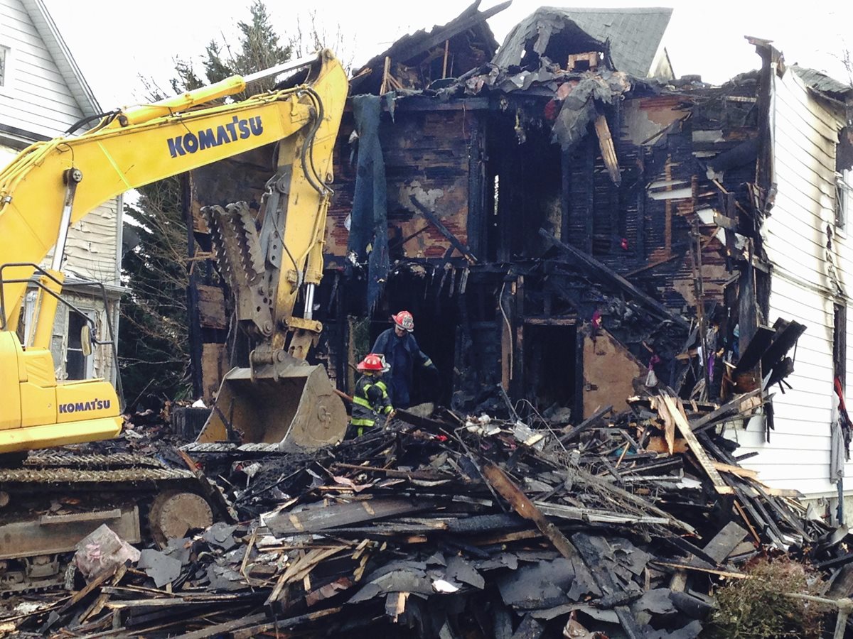 Maquinaria remueve los escombros del lugar donde ocurrió la tragedia. (Foto Prensa Libre: AP).
