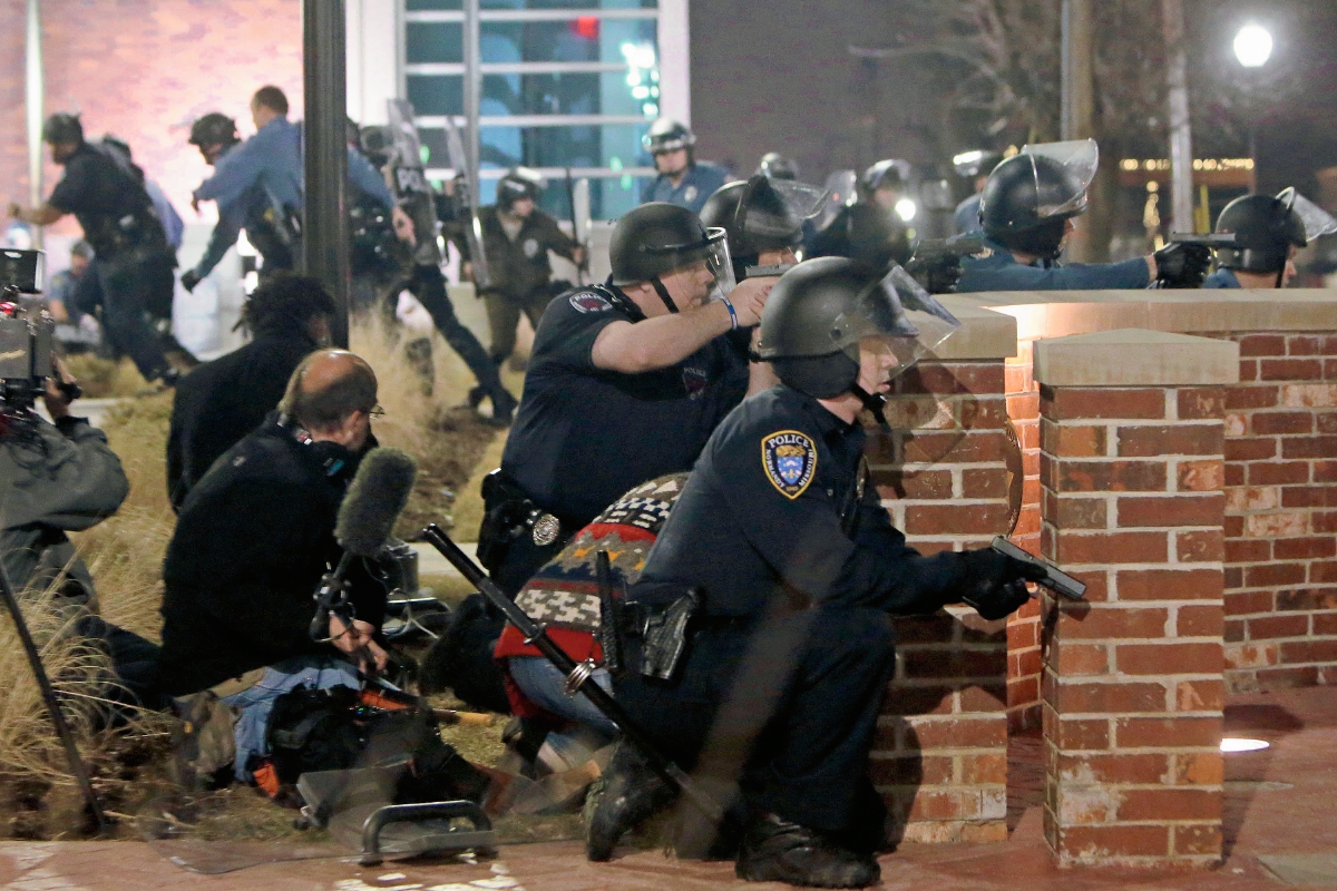 Varios policías  de Ferguson se resguardan tras un muro durante la balacera. (Foto Prensa Libre: AP)