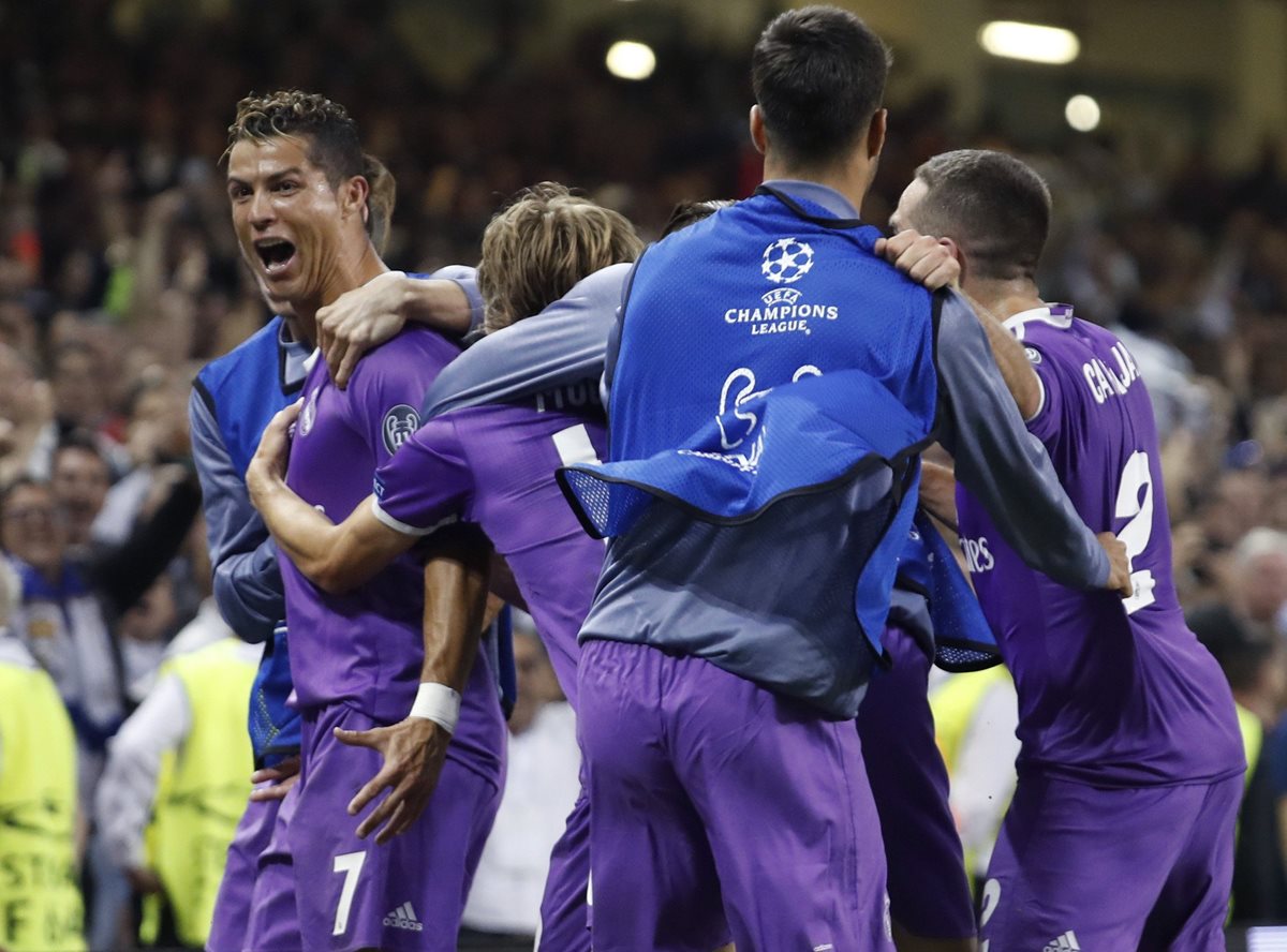 Cristiano Ronaldo es felicitado por sus compañeros luego de su segunda anotación. (Foto Prensa Libre: EFE)
