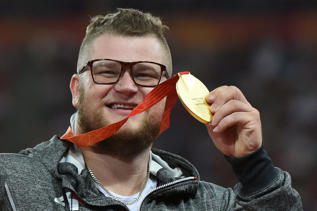 Pawel Fajdek muestra con orgullo la medalla de oro que ganó el domingo recién pasado. (Foto Prensa Libre: AFP)