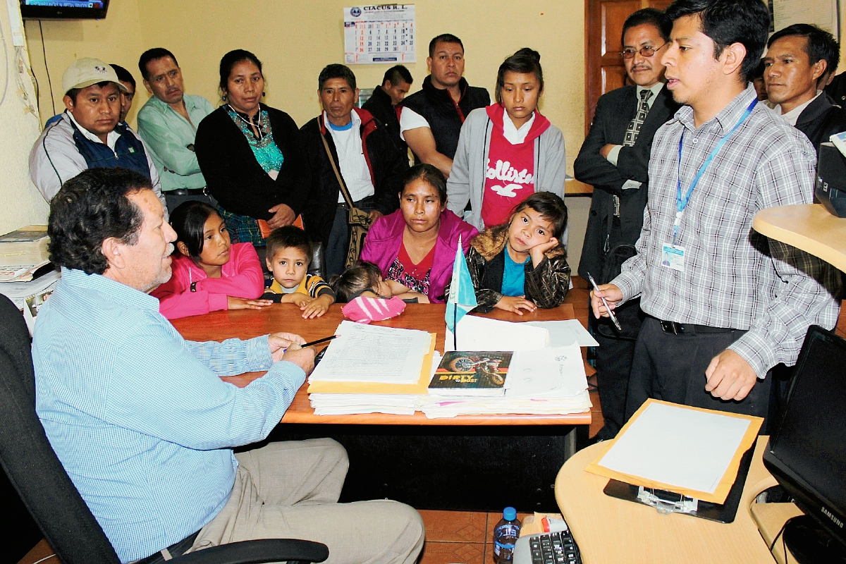 Hugo Samuel  Quijivix  -Der.- del Juzgado de Paz de Cunén, Quiché, explica al secretario de la municipalidad que la reinstalación de los trabajadores fue ordenada por el Juzgado de Trabajo de Nebaj. (Foto Prensa Libre: Óscar Figueroa)
