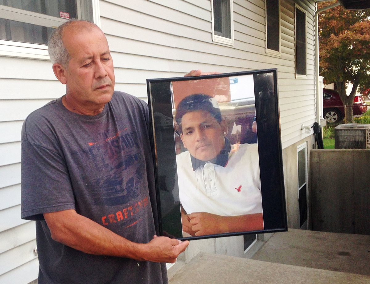 Abraham Chaparro sostiene la fotografía de su hijastro, Miguel García Morán, quien habría sido asesinado por integrantes de pandillas centroamericanas. (Foto Prensa Libre: AP).