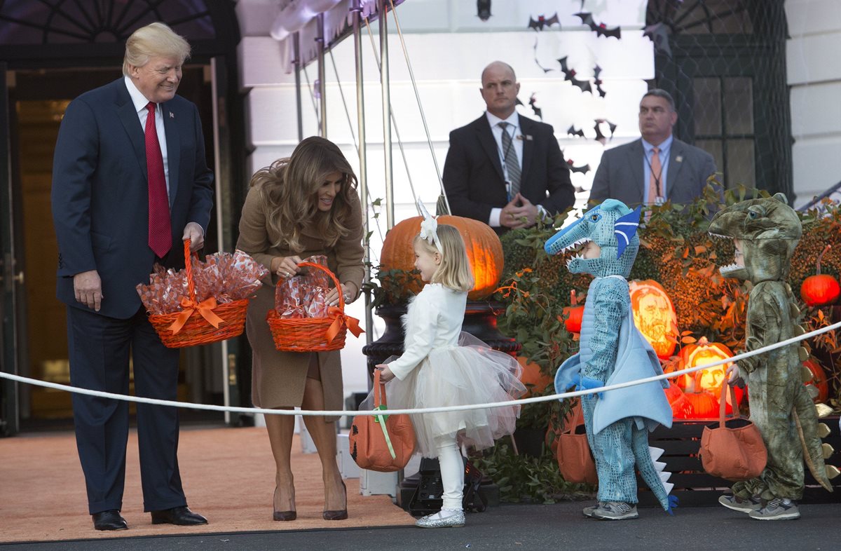 Donald Trump y su esposa, Melania, entregan golosinas a niños disfrazados en la Casa Blanca. (Foto Prensa Libre: EFE)
