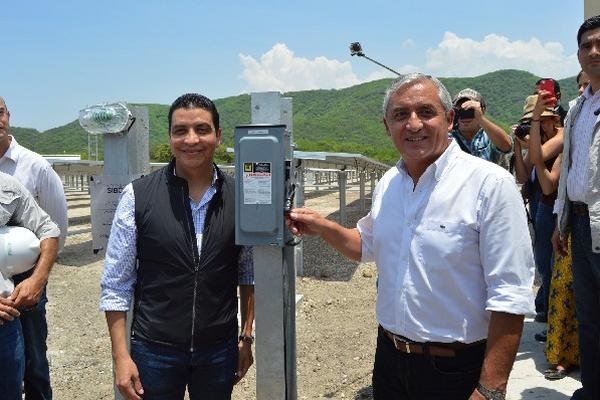 El ministro de Energía y Minas, Érick Archila, y el presidente Otto Pérez Molina sonríen al poner en funcionamiento la primera planta solar del país.