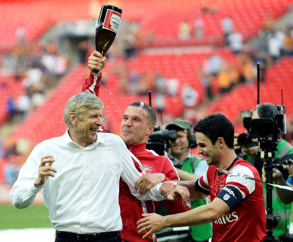 Fotografía de archivo del técnico del Arsenal, Arsene Wenger (i), durante la celebración de su victoria en la final de la FA Cup entre el Arsenal y el Hull City en el estadio de Wembley en Londres (Reino Unido), el 17 de mayo de 2014. (Foto Prensa Libre: EFE)