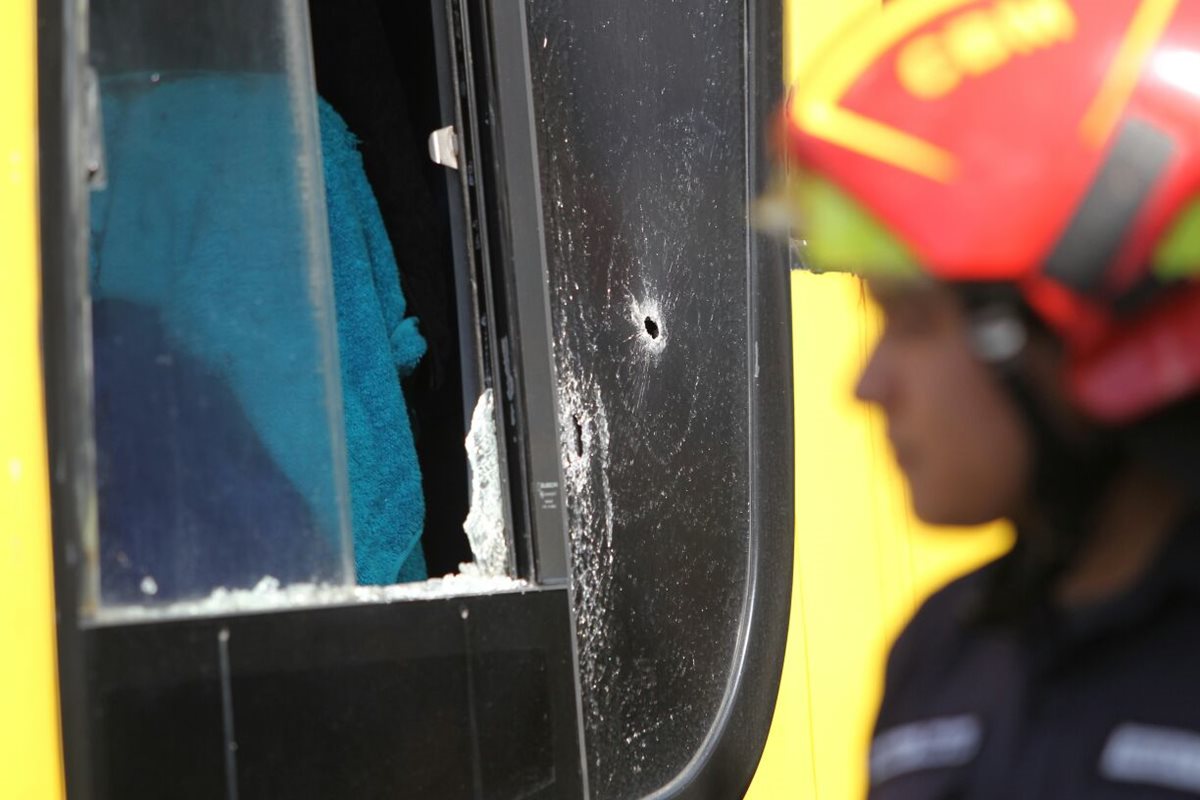 Un orificio de bala se observa en la ventanilla del lado del piloto en el bus pullman atacado este domingo en la calzada Aguilar Batres. (Foto Prensa Libre: Érick Ávila)