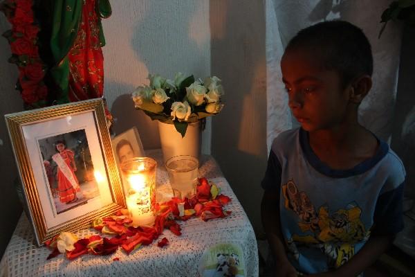 Niño llora mientras observa la fotografía de María Elena Hernández, en el lugar donde son velados sus restos, en Casillas, Santa Rosa.