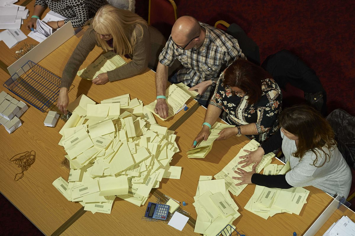 Miembros de una mesa cuentan las boletas para determinar la cantidad de votos. (Foto Prensa Libre: AFP).