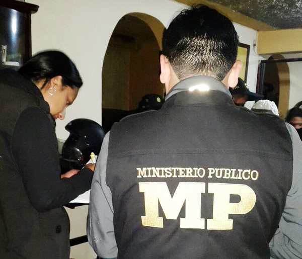 Fiscales del Ministerio Público levantan un acta en una de las viviendas donde detuvieron a uno de los implicados. (Foto Prensa Libre: MP)