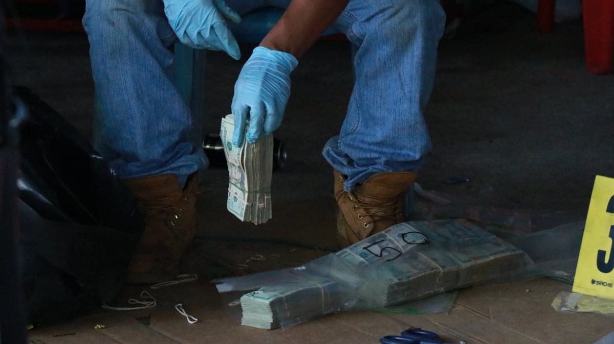 Un fiscal del MP cuanta parte de los dólares incautados en Cocales, Patulul, Suchitepéquez. (Foto Prensa Libre: Cristian Soto)