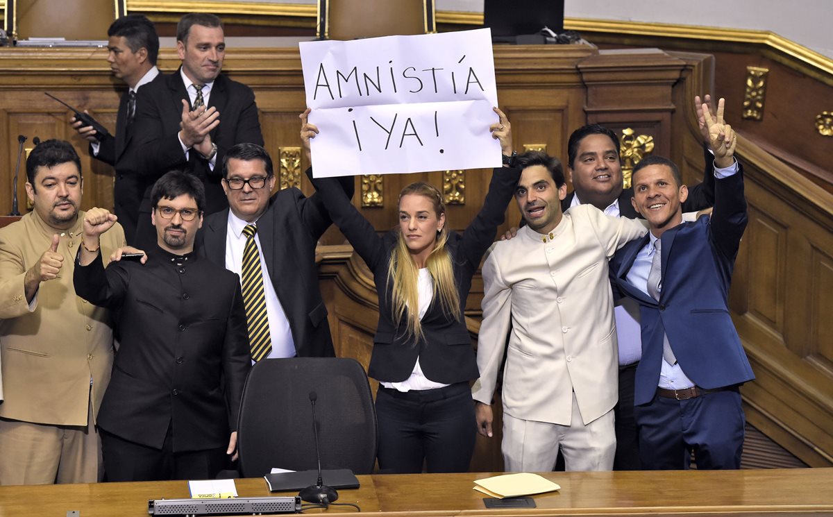 Lilian Tintori, esposa del opositor Leopoldo López, sostiene un cartel donde exige la ley de amnistía. (Foto Prensa Libre: AFP).