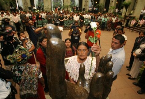 Ana Pérez Tum efectúa el cambio de la rosa, junto con Pedro Maas Chen —derecha— y Catarina Brito —de espaldas, a la izquierda—, cuyos familiares fueron desaparecidos.