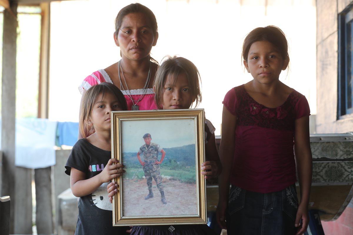 Las hijas de Nohemí sostienen la fotografía con la que recuerdan a su padre asesinado en 2012 por tropas beliceñas. (Foto Prensa Libre: Érick Ávila)