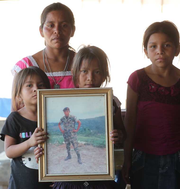 Las hijas de Nohemí sostienen la fotografía con la que recuerdan a su padre asesinado en 2012 por tropas beliceñas. (Foto Prensa Libre: Érick Ávila)