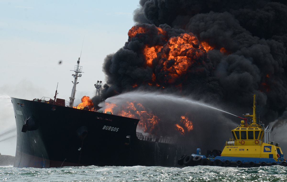 Una embarcación apagafuegos intenta sofocar las llamas del buque que explotó en el Golfo de México. (Foto Prensa Libre: EFE).