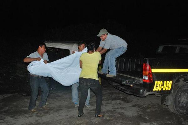 Empleados de una funeraria trasladan a la morgue el cadáver de Juan Cen, quien murió baleado, en La Gomera. (Foto Prensa Libre: Enrique Paredes)