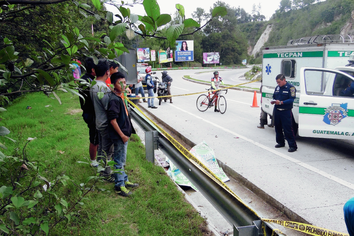 Bomberos Municipales Departamentales y vecinos, en el km 85 ruta Interamericana, Tecpán Guatemala, Chimaltenango, donde murió el agente de la Policía Nacional Civil, al caer de un bus en marcha. (Foto Prensa Libre: José Rosales)