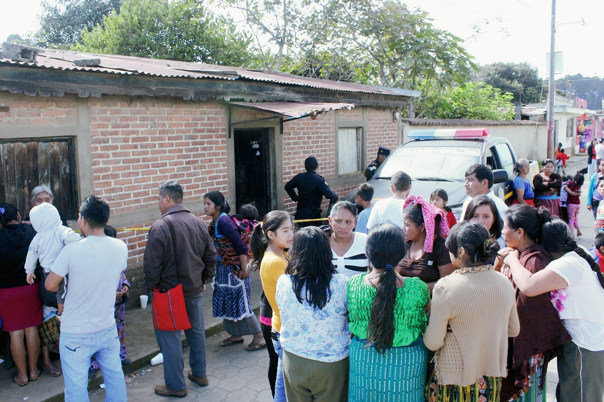 Familiares y vecinos de Rubén Inay, quien fue hallado muerto en su vivienda, en Chimaltenango, observan mientras las autoridades realizan las diligencias respectivas en la escena. (Foto Prensa Libre: Víctor Chamalé)