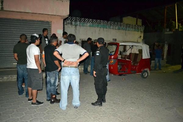 Curiosos y policías observan el mototaxi en donde fue ultimado Élmer Larios.