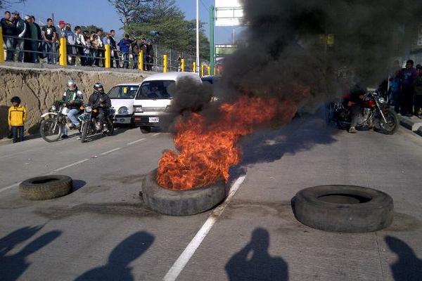 Manifestantes queman llantas frente a la Centra Norte. (Foto Prensa Libre: Estuardo Pardes)