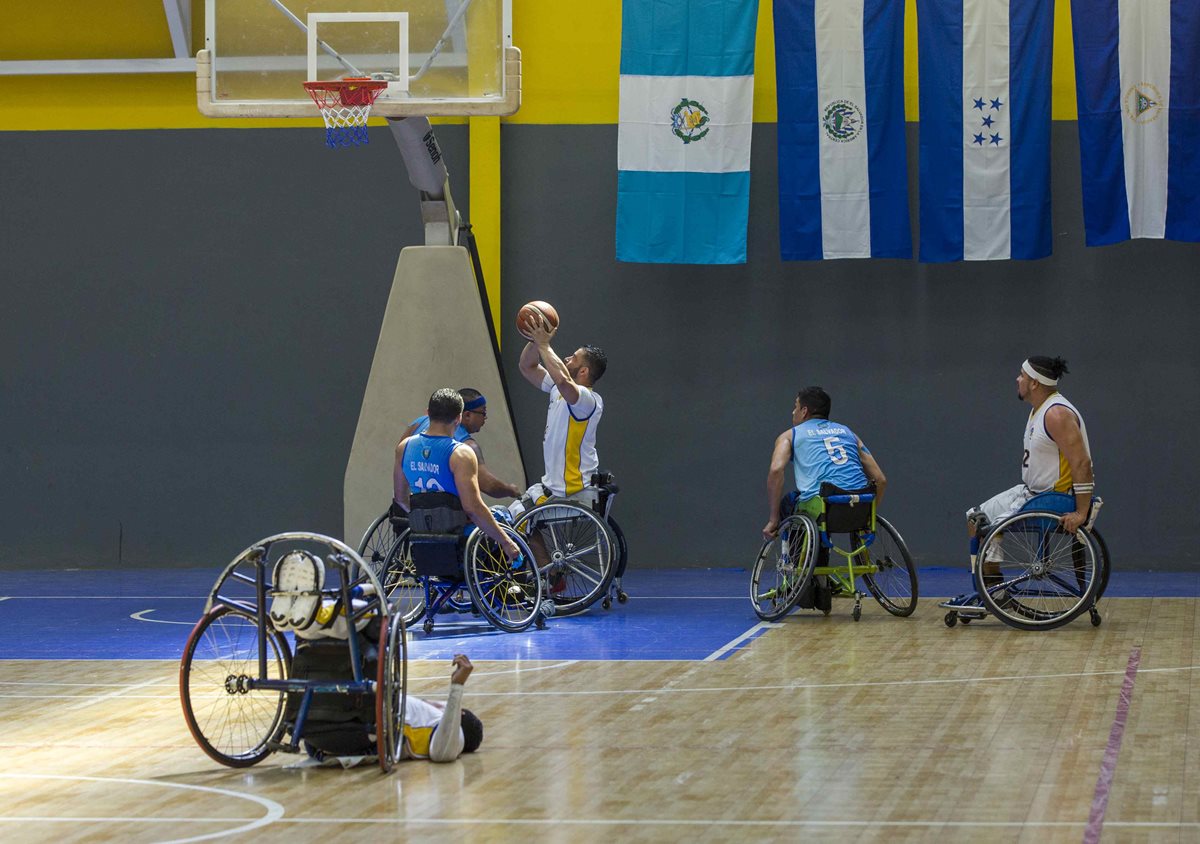 El jugador nicaragüense Ariel Calderón (C) anota contra El Salvador durante la final de baloncesto en silla de ruedas. (Foto Prensa Libre: EFE)