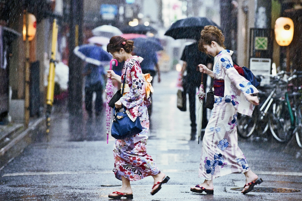 Dos mujerescorren bajo la lluvia del tifón Nangka en una calle de Kyoto, Japón. (Foto Prensa Libre: EFE).