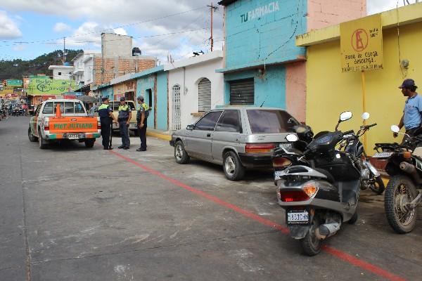 Policías municipales controlan estacionamiento  de vehículos en calle aledaña a mercado, en Jutiapa.
