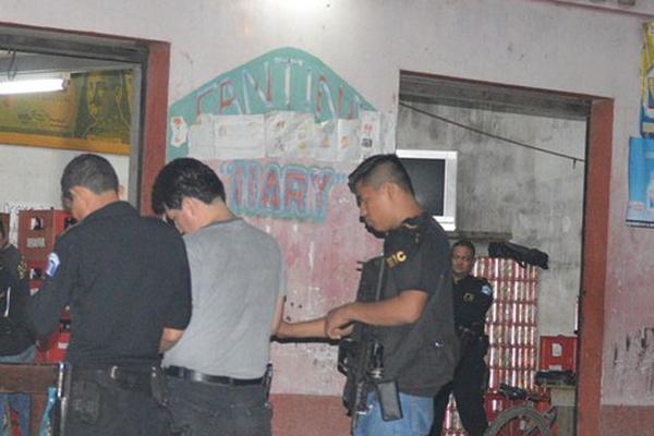 Investigadores observan el cadáver de Carlos Humberto Ramos, quien murió baleado, en La Gomera. (Foto Prensa Libre: Enrique Paredes)